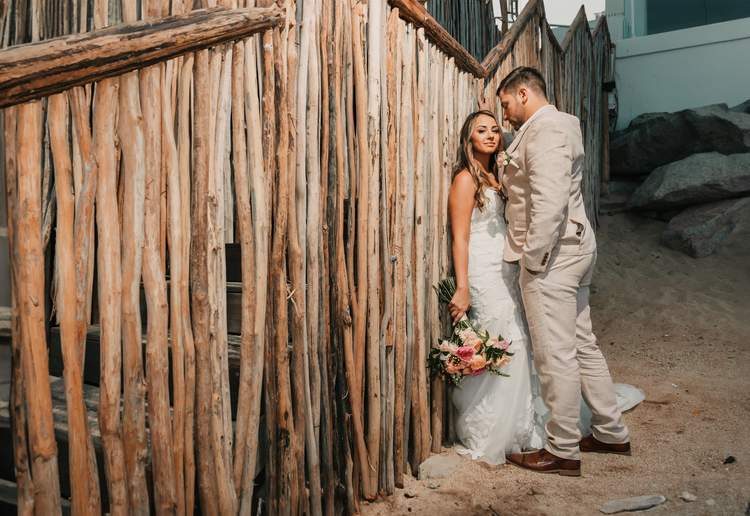 Wedding couple against driftwood wall Cabo San Lucas — Ana Badillo Photography