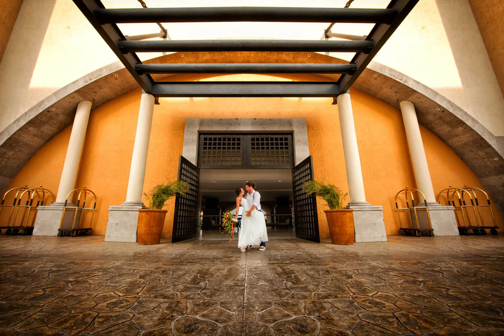 Pareja de novios en la entrada de un resort de lujo