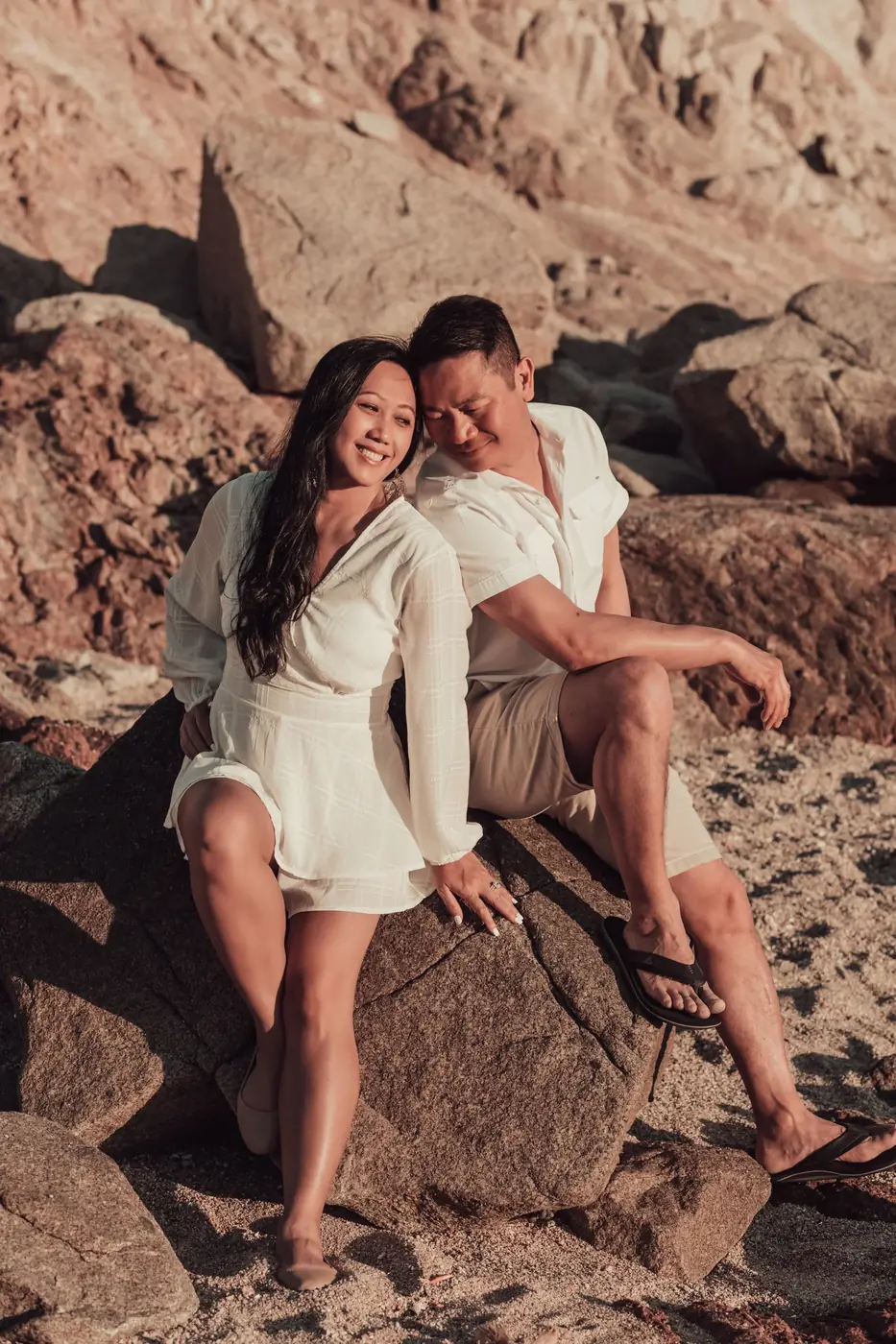 A relaxed couple laughing naturally on a Cabo beach, photographed by Ana Badillo — proof that camera-shy couples make the most genuine photos